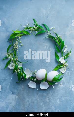 Easter wreath with eggs, green leaves and spring flowers. Floral decoration concept with copy space. Stock Photo