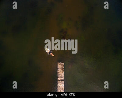 A tourist jumps of a pier into a lake in Zimbabwe's little Connemara, Nyanga. Stock Photo