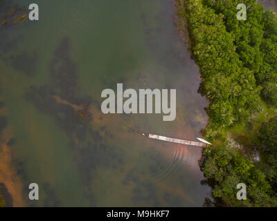 A tourist jumps of a pier into a lake in Zimbabwe's little Connemara, Nyanga. Stock Photo