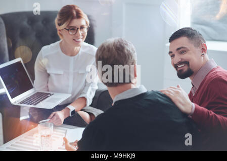 Happy bearded man looking at his colleague Stock Photo