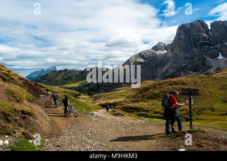 Dolomites, Trentino Alto Adige,Italy: some trekkers and bikers rest on a  trail in Fassa valley Stock Photo