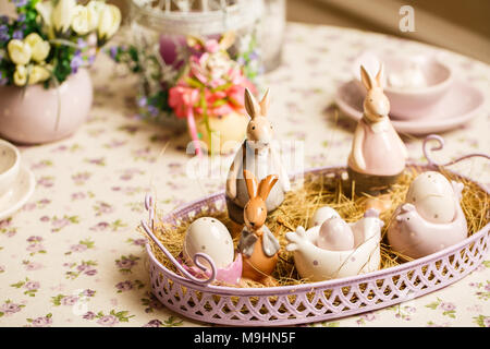 Porcelain Easter bunnys or rabbits with eggs on the table Stock Photo
