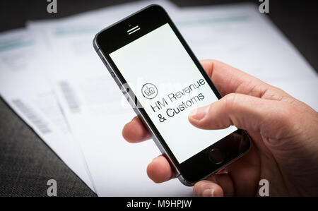 A man using the HMRC HM Revenue and Customs app on an iPhone in the UK Stock Photo