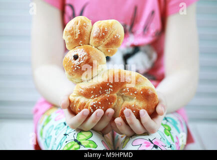 Big dough bunny  in the hands of a child, freshly baked for easter holidays, Baking with kids. Selective focus Stock Photo