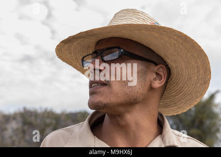 VINALES, CUBA - MARCH 14, 2018. Cuban man with a white hat on and glasses a tobacco farm.. Vinales Cuba. Stock Photo