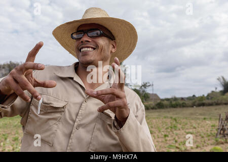 VINALES, CUBA - MARCH 14, 2018. Cuban man with a white hat on and glasses a tobacco farm.. Vinales Cuba. Stock Photo