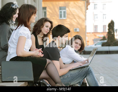 group of students communicating via the Internet using laptop Stock Photo