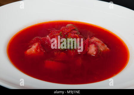 Borsch - a soup of beets in an earthenware bowl on a cipher, a stone or metal background, a traditional Ukrainian dish. Stock Photo