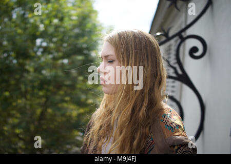 Girl with eyes closed, on balcony, Paris, France Stock Photo