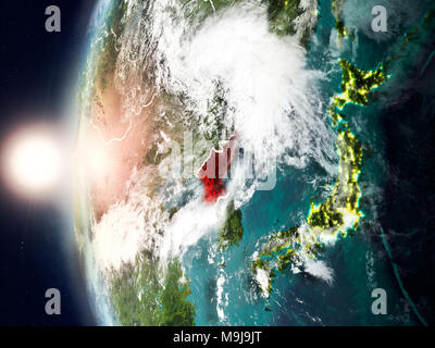 Satellite view of North Korea highlighted in red on planet Earth with clouds and visible country borders during sunset. 3D illustration. Elements of t Stock Photo