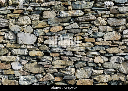 Stones of different shapes, sizes and colours in a dry stone wall made from local rocks in Geopark. Rhoscolyn, Isle of Anglesey, Wales, UK, Britain Stock Photo