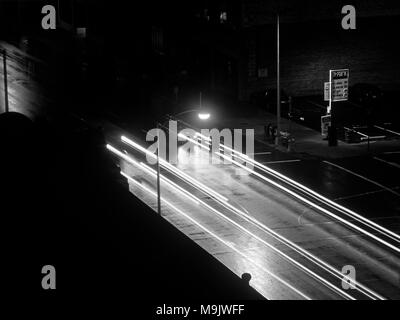 Street scene with light streaks at night eerie feeling downtown in black and white Stock Photo