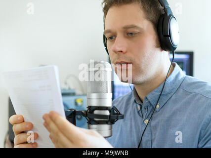 Handsome man recording an advertisement on the radio station. Stock Photo