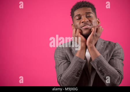 young black man with closed eyes is touching his chin with hands. adore beard. like beard. dreaming Afro man.sentimental man Stock Photo