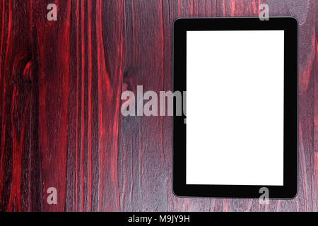 Black tablet with white screen and placed on top of mahogany wood. Stock Photo