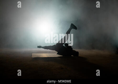 Handsome male dancer spinning on the back. performing backspin on the floor.kind of break dance Stock Photo