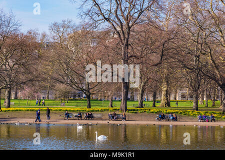 LONDON, UNITED KINGDOM - MARCH 21: People sitting by the lake in St James's Park on a sunny day in spring on March 21, 2018 in London Stock Photo