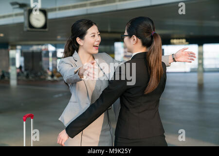 Two happy Businesswomen hugging each other in the station. Stock Photo