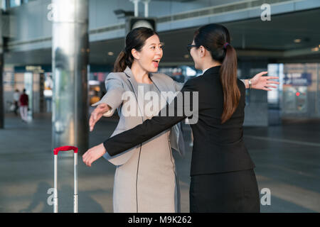 Two Asian businesswomen met each other so happy. They are going to give each other a big hug. Stock Photo