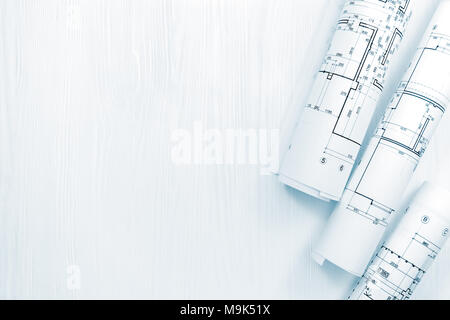 rolled architectural blueprints and engineering drawings for house renovation on architect workplace Stock Photo