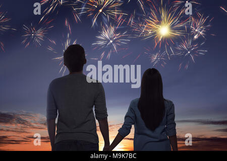 Young asian couple watching spectacular fireworks on the sky Stock Photo