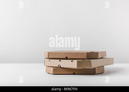 three pizza boxes on white tabletop Stock Photo