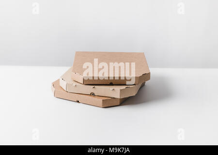 three pizza boxes on white table Stock Photo