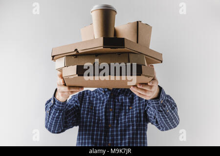 courier holding pizza boxes and coffee in paper cup isolated on white Stock Photo