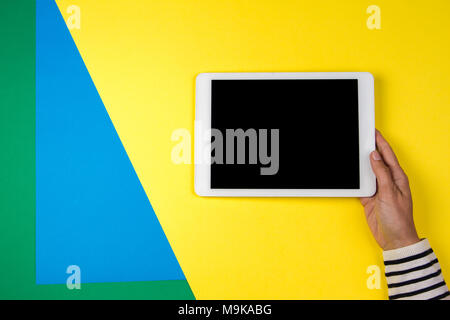 Woman's hands with tablet computer on colorful background Stock Photo