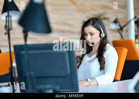 Attractive woman listening to music while working in startup business office Stock Photo