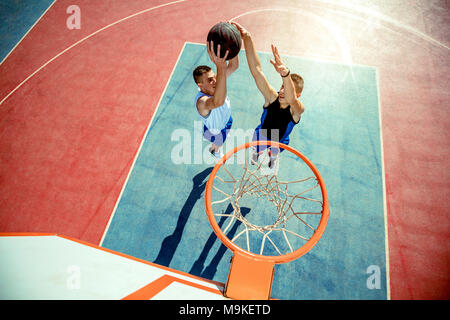 High angle view of basketball player dunking basketball in hoop Stock Photo