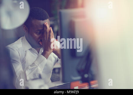 Stressed tired freelancer is having headache and thinking how to finish his work. Stock Photo