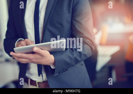 Midsection of businessman using digital tablet in office Stock Photo