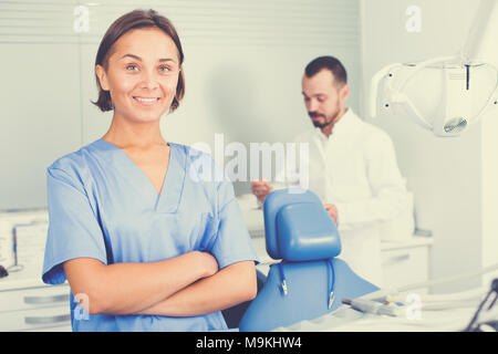 Young doctor with assistant are posing on workplace in hospital Stock Photo