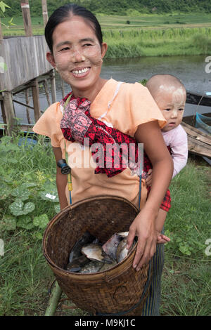 Mother with baby selling fresh fish. Lake Inle, Shan State, Myanmar. Stock Photo