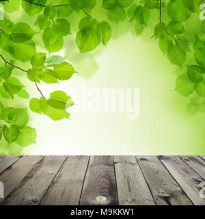 Spring bokeh background. Abstract Bokeh Light, Green Linden Leaves and Grey Empty Wooden Table Stock Photo