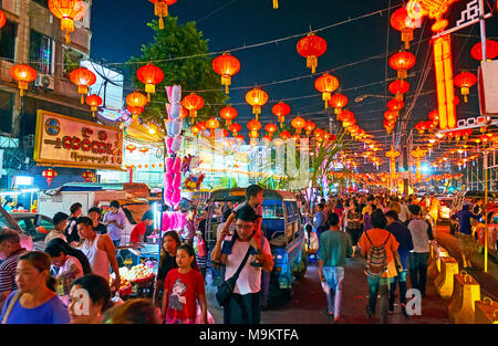 YANGON, MYANMAR - FEBRUARY 14, 2018: Walk in crowded Maha Bandula Road of Chinatown during Chinese New Year celebration, avenue is decorated with nume Stock Photo