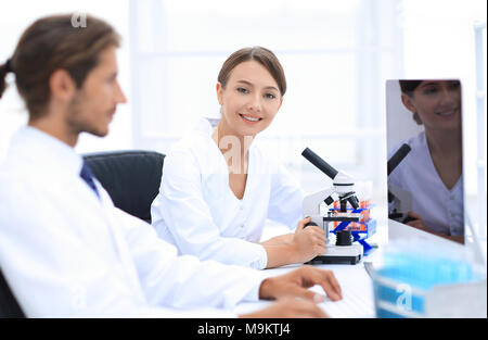 Lab expert working on a test using microscope Stock Photo