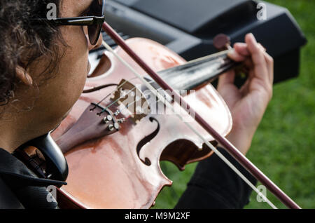 Musician with his violin playing in the street Stock Photo