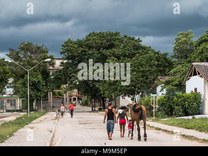 Las Tunas, Cuba - September 4, 2017: A man, woman, and young boy holding a rope leash walk a horse at the city fairgrounds. Stock Photo