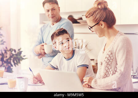 Positive delighted boy doing his lessons Stock Photo