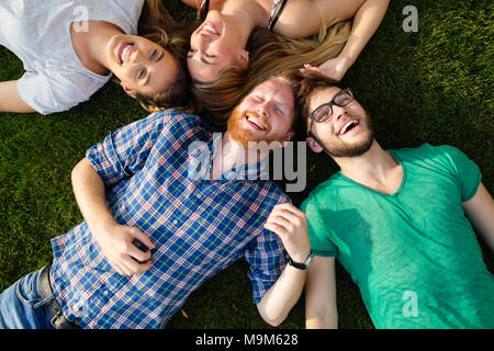 Happy students lying on ground and smiling Stock Photo
