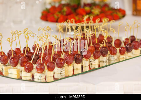 Rows of tasty mini canapes with brie cheese and grapes.Canape with cheese and grape Stock Photo