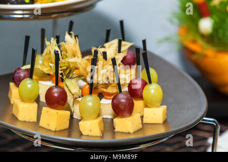 Rows of tasty mini canapes with brie cheese and grapes.Canape with cheese and grape Stock Photo