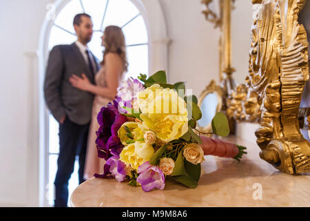 Wedding shot of bride and groom focus on bouquet.Young wedding couple enjoying romantic moments. Wedding celebrations.