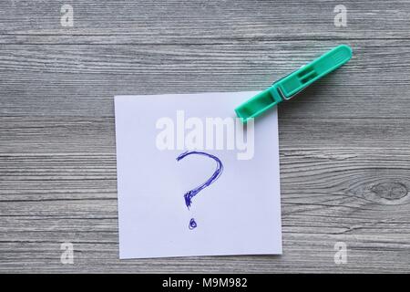 Handwritten notes on white paper, coloured clothes peg, grey plank background, space for copy Stock Photo
