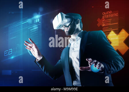 Progressive programmer wearing amazing virtual reality device while working Stock Photo