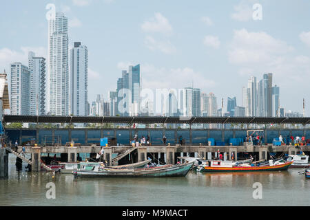 Panama City, Panama - march 2018: Fishermen and boats on fish market / harbour with city skyline, Panama City. Stock Photo