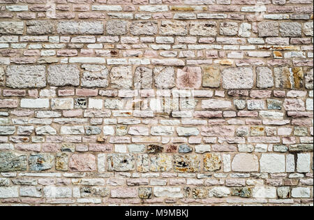 Stones and bricks mixed in a traditional wall construction of center Italy. Stock Photo