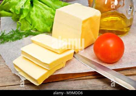 butter in parchment paper and vegetables on a wooden table  Stock Photo